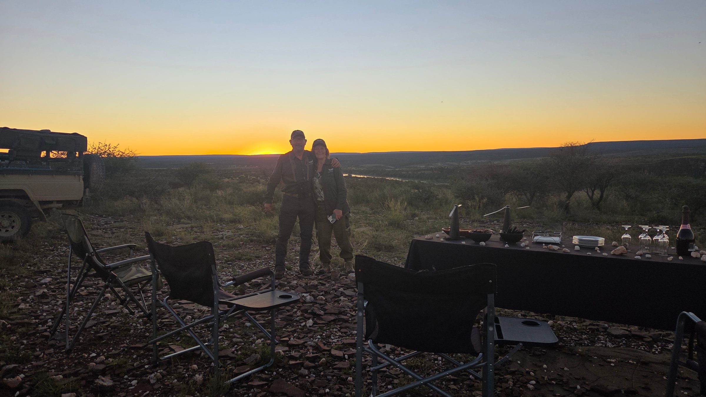 Two guests by the sundowner table as the sun sets