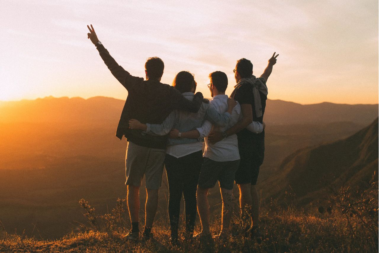 Friends on a mountain ridge at sunset