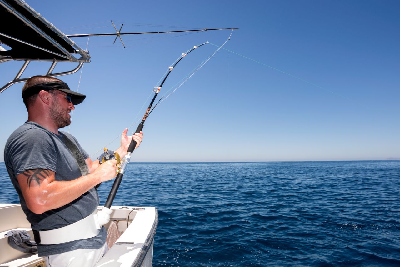 An angler fights a fish from the boat