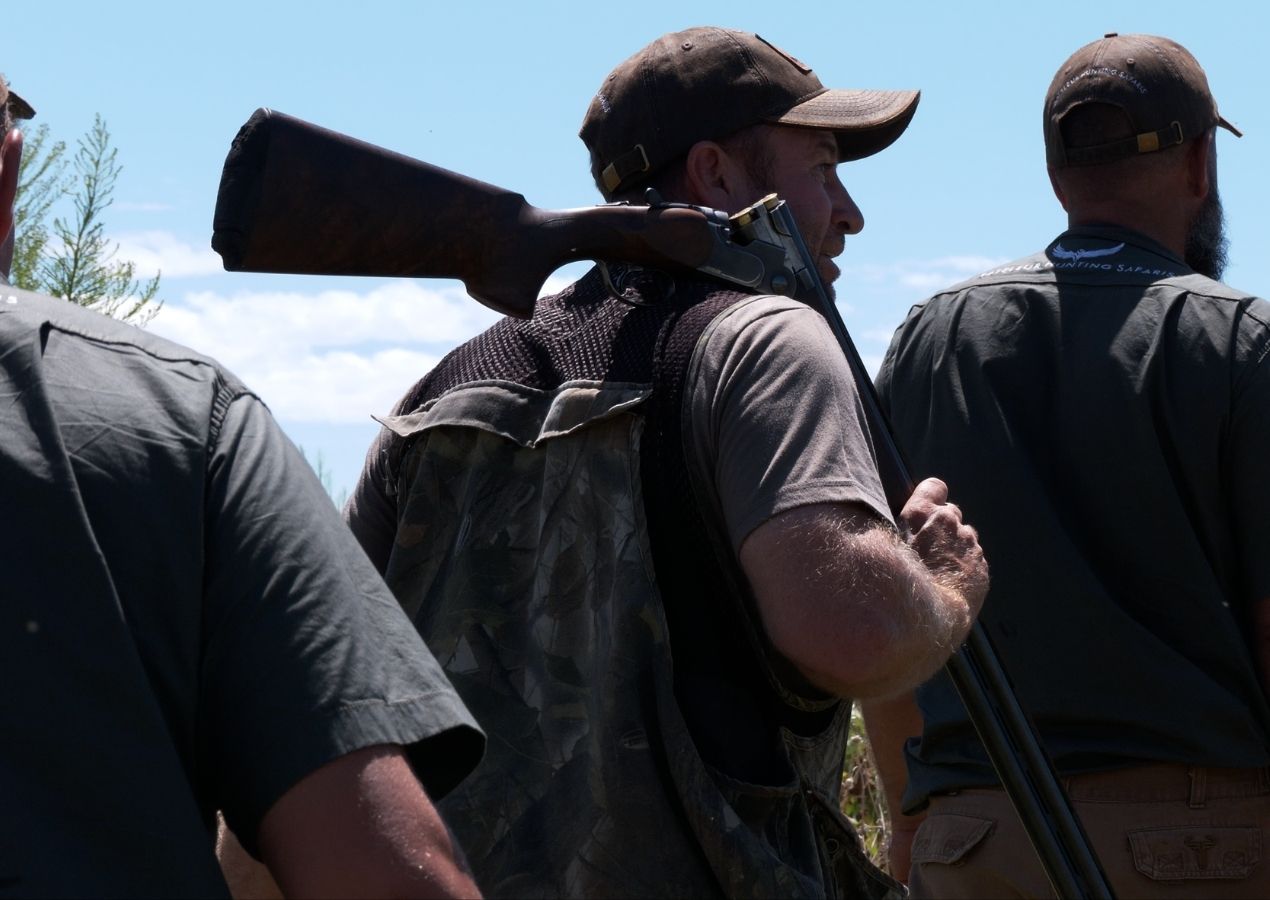 Two Bateleur hunters walk out with a rifle