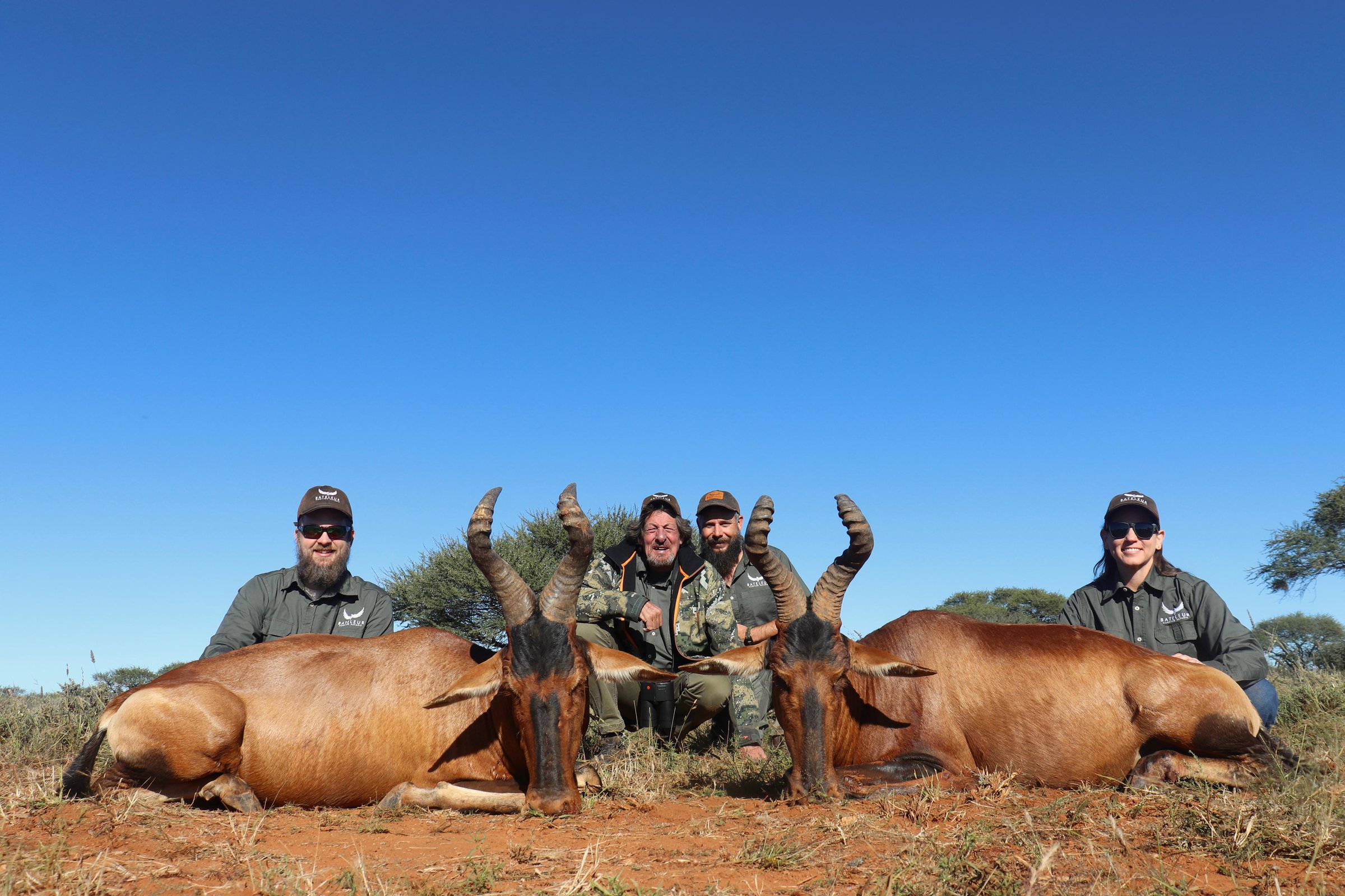 Four hunters with two red hartebeest