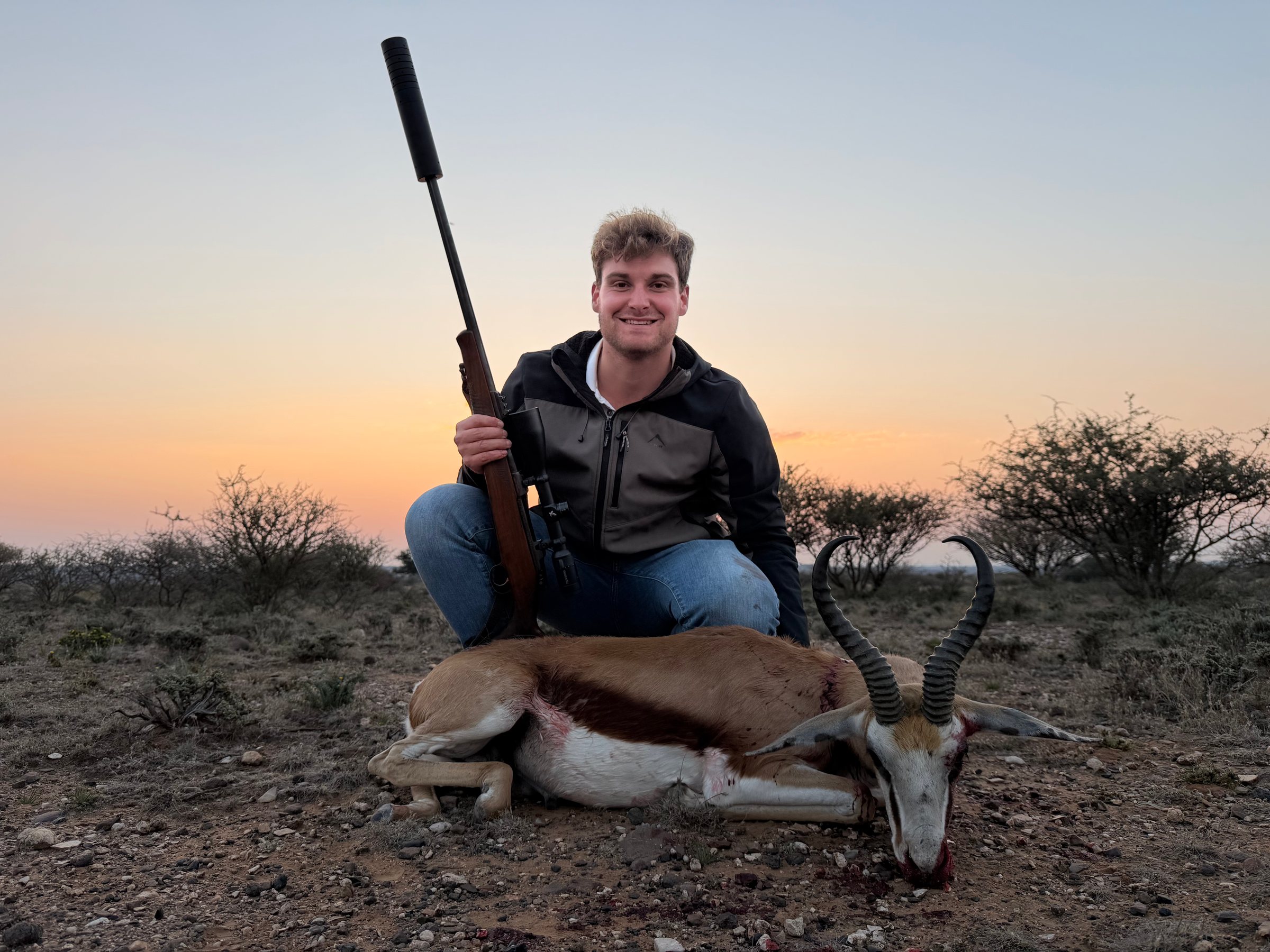 A hunter with his springbok at dusk