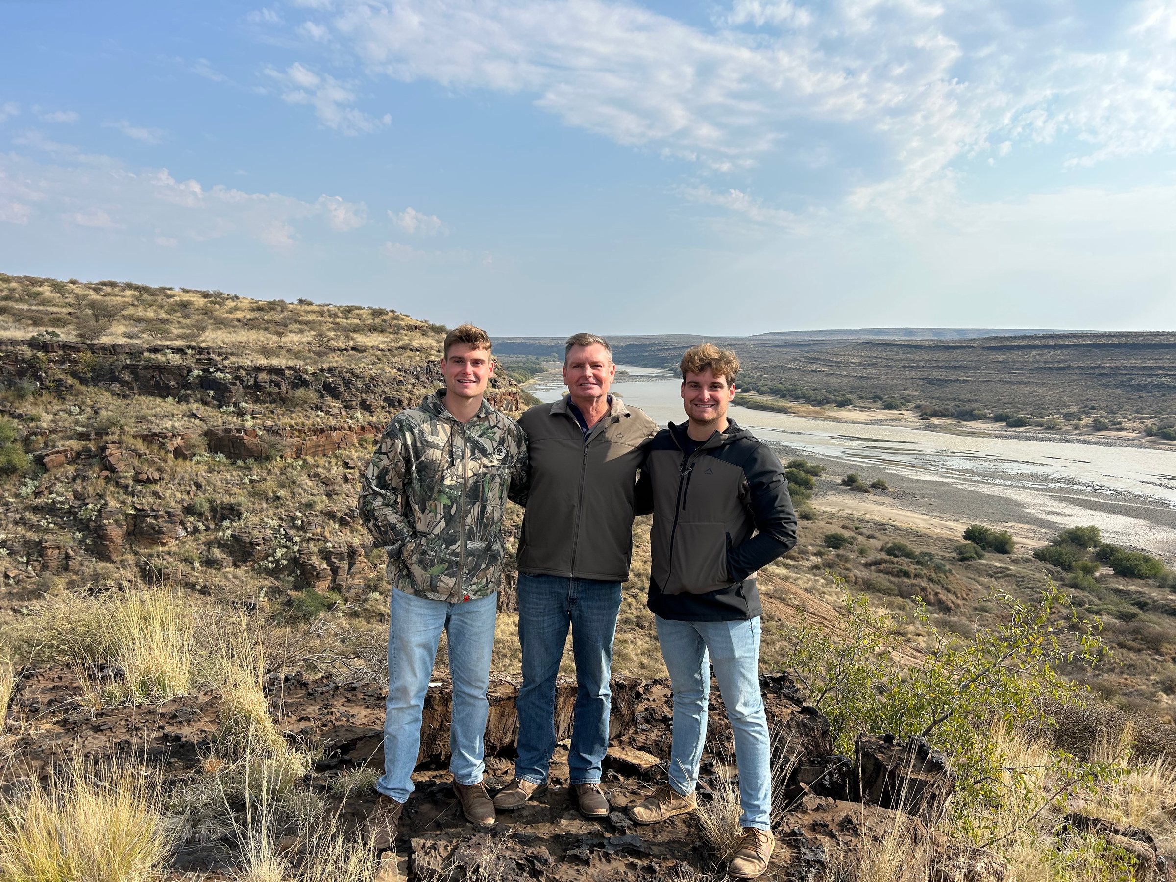 Three guests on the rocks above the river gorge