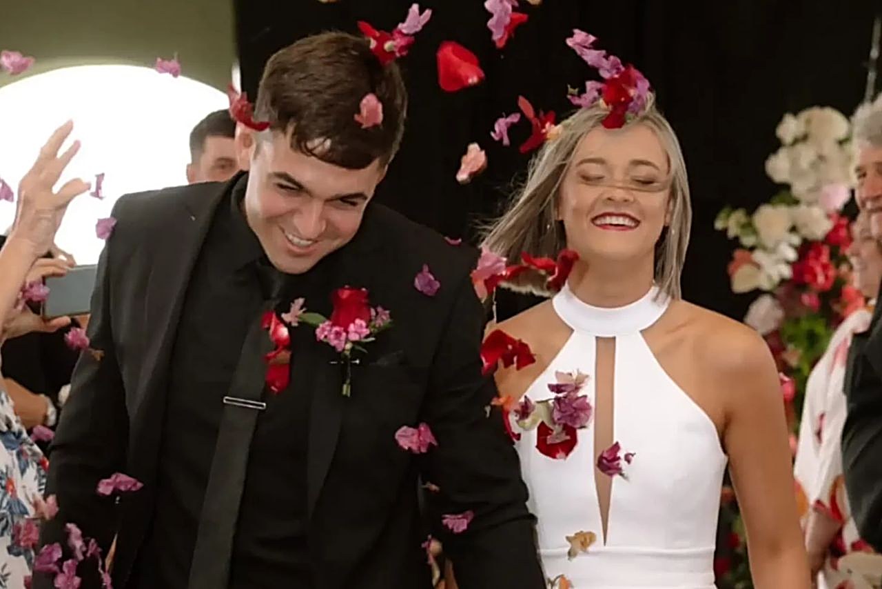 A bride and groom beneath a shower of rose petals